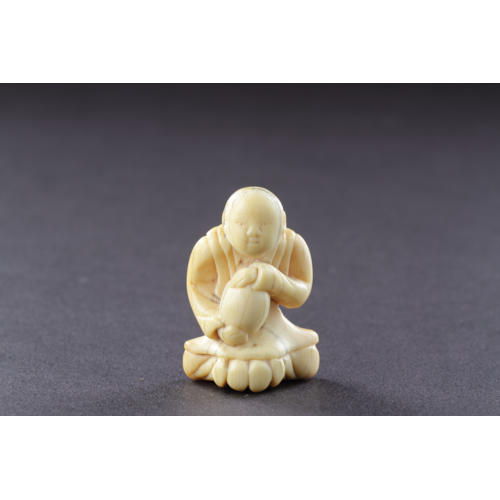 Japanese Ivory Netsuke of a Man Seated Wearing a Mon Decorated Kimono Clasping with Both Hands his Treasured Saké Gourd